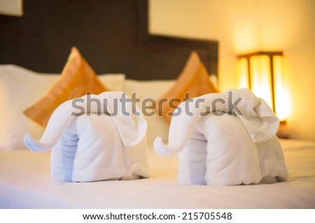 Towels in form of elephants on luxury bed in tropical beach hotel
