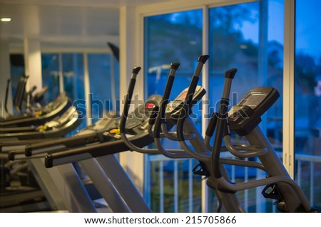 Elliptical cross trainers in a fitness gym at evening