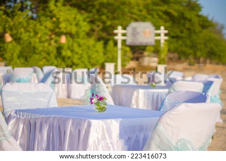 Luxury beach restaurant with tables and chairs covered with white cloth on tropical beach island
