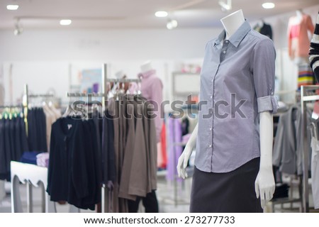 Everyday dressed woman mannequin with grey color blouse and skirt in store