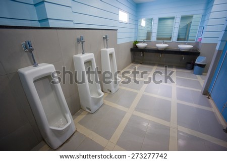 Public toilet with pissoirs and sinks in blue colors