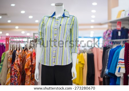 Everyday dressed woman mannequin with light color blouse and trousers in store