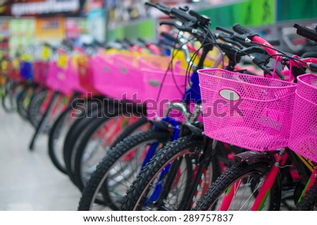 Row of bicycles with pink baskets in supermarket
