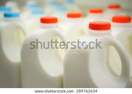 Rows of large milk bottles in fridge in supermarket