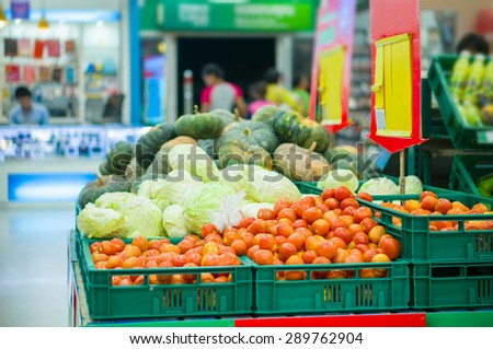 Bunch of tamato, cabbage and pumpkin in boxes in supermarket