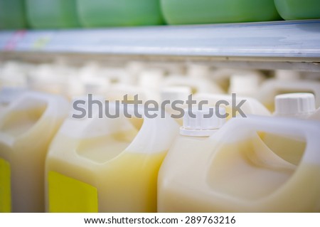 Rows of large juice bottles in fridge in supermarket