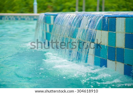 Water flow down from small pool to large one in open air aqua park