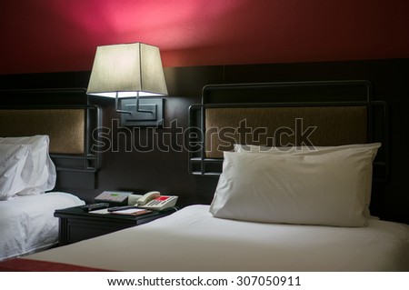 Beds with bed light on in luxury hotel room in the evening