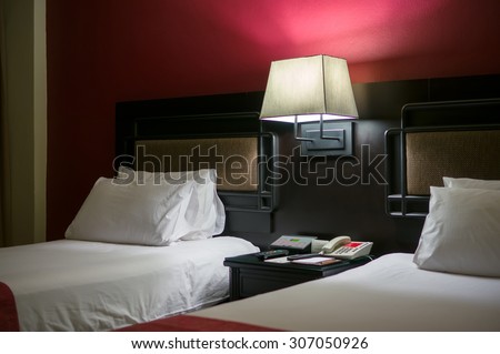 Beds with bed light on in luxury hotel room in the evening