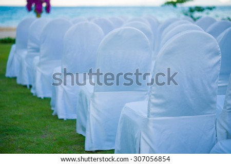 Rows of white covered chairs for asian buddhist wedding ceremony