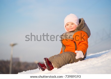 Adorable wondered baby sit on top of mountain on sunset look to sun side and smile