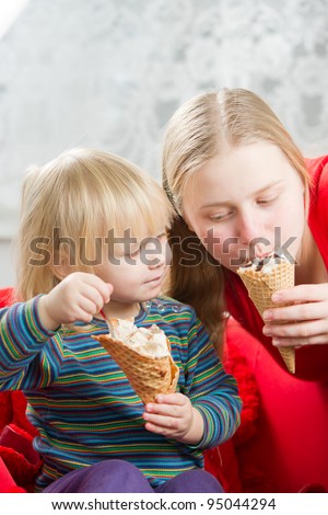 Mother and baby eat ice cream in kitchen