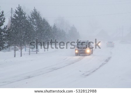 Winter, snow, Blizzard, poor visibility on the road. Car during a Blizzard on the road with the headlights.