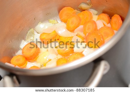 Carrot and onion with oil in pan