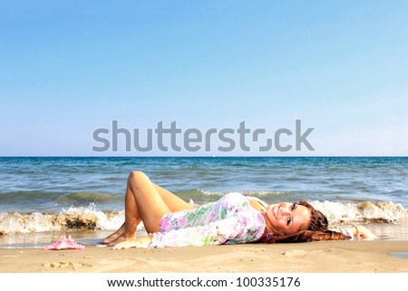 Young woman laying on a beach and enjoying the sun