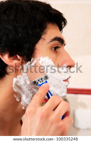 Young man shaving in the bathroom