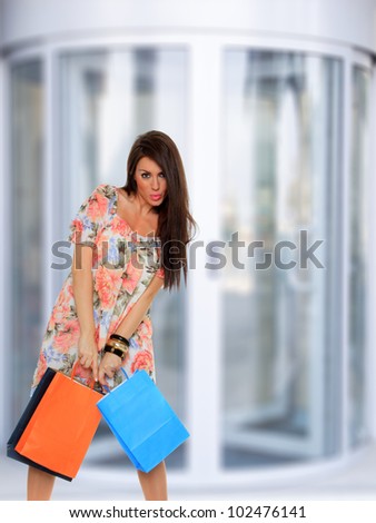 Modern woman shopping in mall holding bags