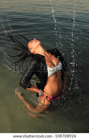 Motion freeze on a girl splashing the sea water with her hair