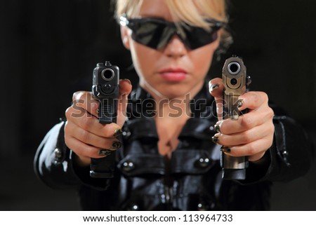Beautiful sexy blond woman with guns - Selective focus on the gun