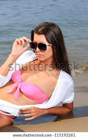 beautiful young woman in white shirt and pink bikini  portrait on beach