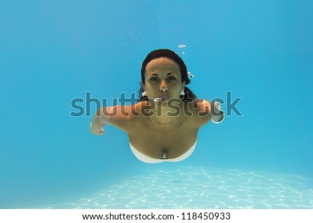 Underwater woman close up portrait in swimming pool.