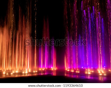 Large multi colored decorative dancing water jet led light fountain show at night