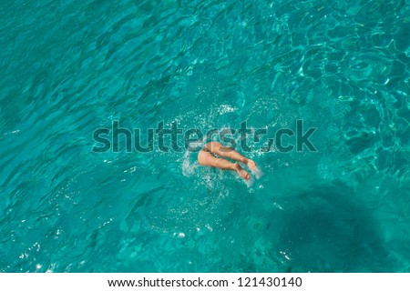 Beautiful young woman diving in the sea in Greece