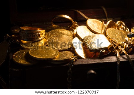 Jewels and gold coins over dark background