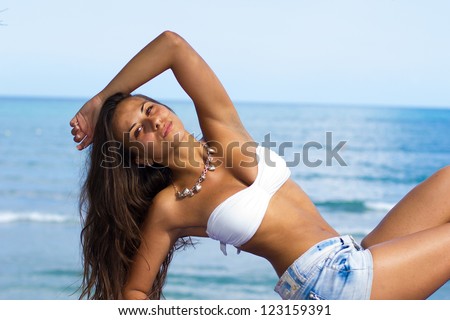 Beautiful young woman jeans shorts and bikini top