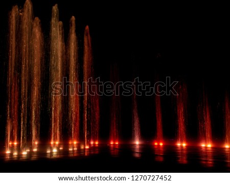 Large multi colored decorative dancing water jet led light fountain show at night