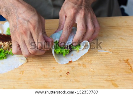 Man making spring rolls at the market