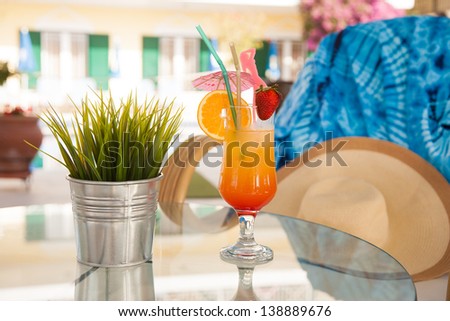 Glass of Tequila sunrise cocktail garnished with wild strawberries