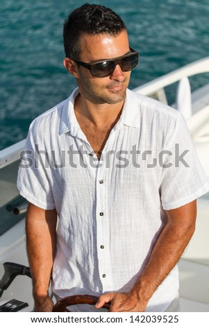 Handsome Young man on his yacht at sea