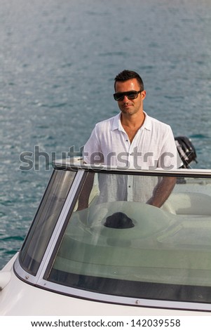 Handsome Young man on his yacht at sea