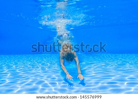 Woman diving underwater in the swimming pool