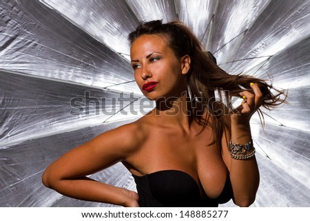 beautiful girl in photo studio silver umbrella in background