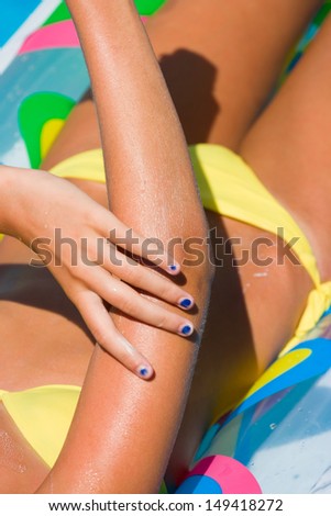 Woman in the swimming pool putting solar cream  Motion blur