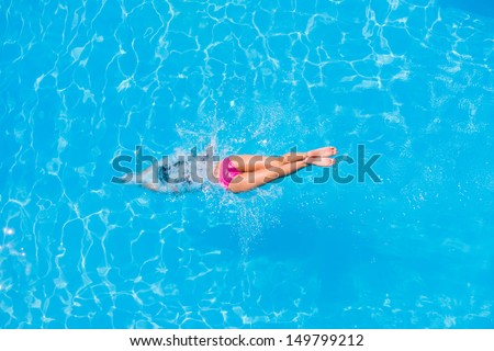 Top view of a girl diving in the swimming pool