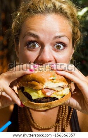 Woman with eating a yummy cheeseburger