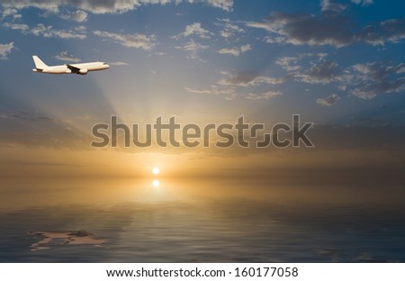 commercial jet airplane in flight at sunset above the sea