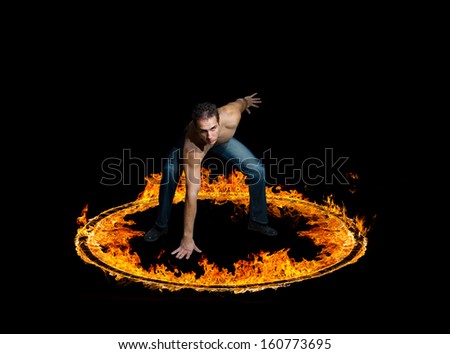 Man in a circle of fire Blazing flames over black background