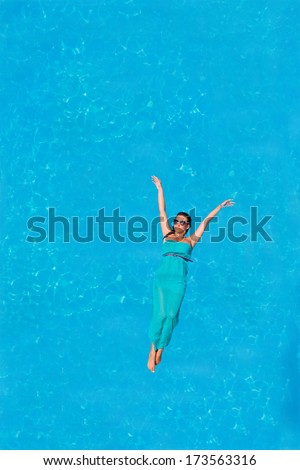 Woman floating above swimming pool water