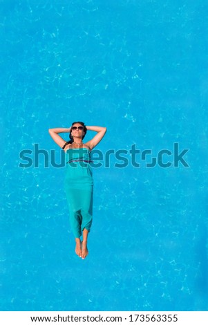 Woman floating above swimming pool water