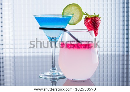 Molecular mixology - two Cocktails with blue caracao and strawberry caviar