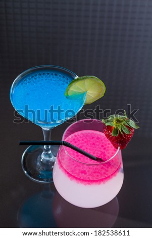 Molecular mixology - two Cocktails with blue caracao and strawberry caviar