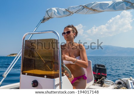 Summer vacation - young girl driving a motor power boat