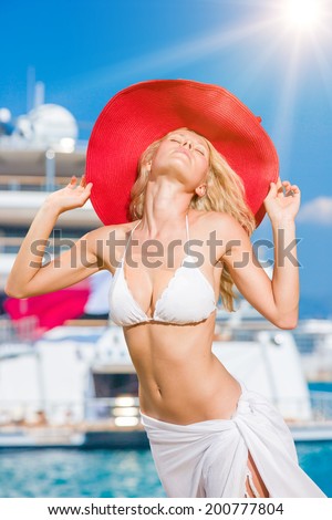 Young woman posing is front of super yacht in Greece
