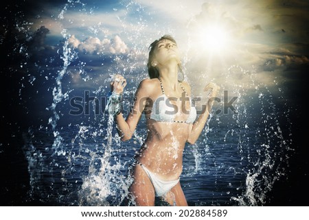 Beautiful woman jumps out of the sea leaving a big splash