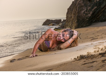 Beautiful woman in bikini top and jeans on the beach. Bali.