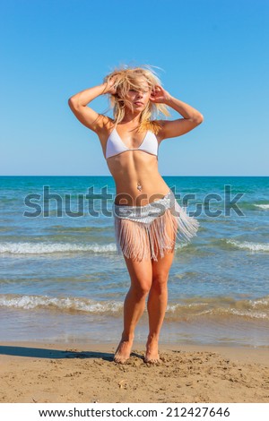 Gorgeous lady in bikini dancing on the beach